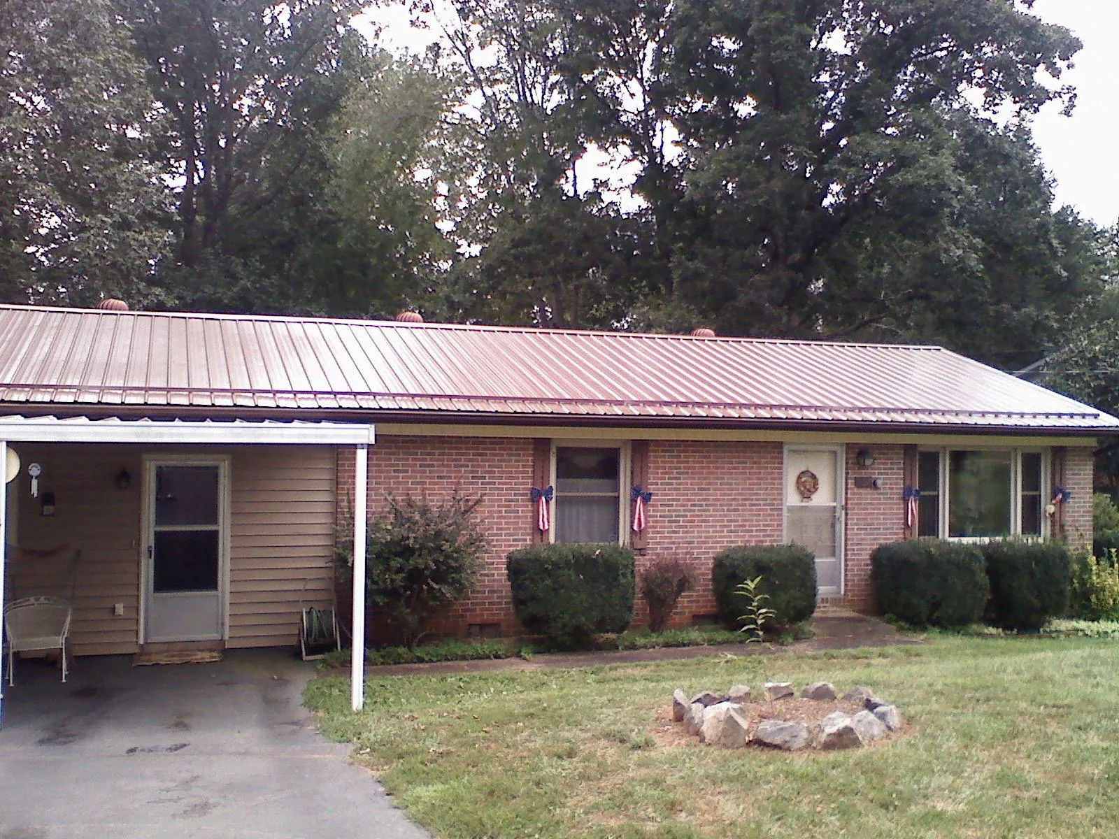 Bronze metal roof and carport on a brick ranch home — Roof Repair work by our crew in Colton
