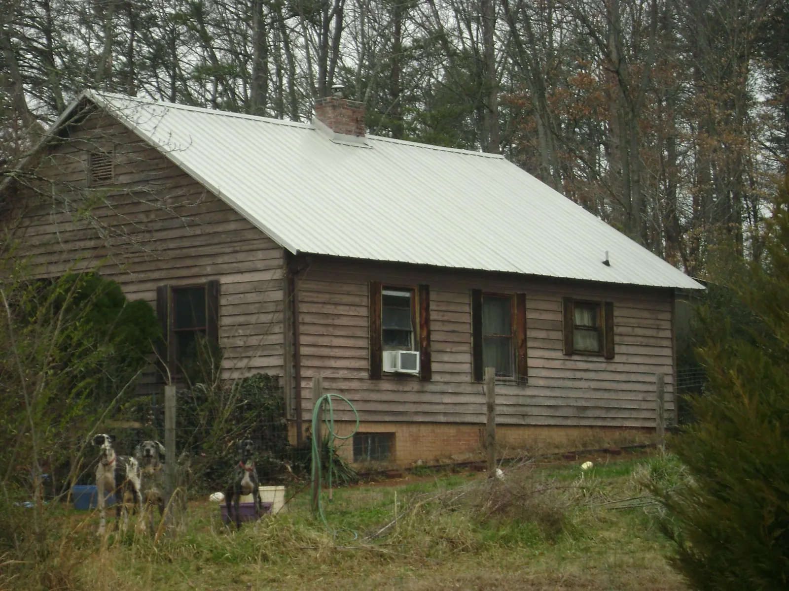 White metal roof on an old wood sided farmhouse, from a Metal Roof Installation job in Colton
